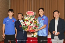 El embajador Nguyen Minh Tam entrega flores a futbolistas vietnamitas.