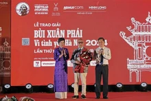 La directora general de la Agencia Vietnamita de Noticias, Vu Viet Trang, entrega el Gran Premio al arquitecto Hoang Dao Kinh. (Foto: VNA)