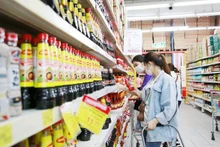 Los consumidores eligen productos en el supermercado Big C Thang Long. (Fotografía: hanoimoi.vn)