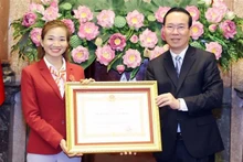 El presidente del país, Vo Van Thuong, entrega la Orden del Trabajo de segunda clase a la atleta Nguyen Thi Oanh- "chica de oro" del atletismo vietnamita. (Fotografía: VNA)