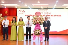 El redactor jefe de Nhan Dan, Le Quoc Minh (primero desde la derecha), entrega flores de felicitación al Consejo Editorial del periódico Ha Tinh. (Fotografía: Nhan Dan)