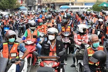 Los mototaxis desfilan frente al Ayuntamiento de Bangkok en marzo del año pasado para alentar a los pasajeros a usar cascos. (Fotografía: bangkokpost)