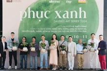 Le Quoc Vinh, representante de la Revista Dep, y Pham Vu Tung, director de marketing de Davines Vietnam, entregan flores a los artistas participantes en el evento. (Fotografía: Nhan Dan)