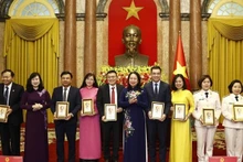 La presidenta interina de Vietnam, Vo Thi Anh Xuan, y los médicos y trabajadores de la salud en la reunión. (Fotografía: VNA)