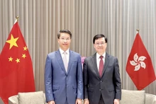 El cónsul general vietnamita, Pham Binh Dam (izquierda), y el jefe ejecutivo de la Región Administrativa Especial de Hong Kong, John Lee, en el encuentro. (Fotografía: VNA)
