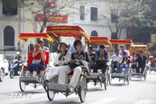 Turistas recorren por Hanói en triciclos. (Fotografía: VNA)