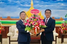 El embajador de Vietnam en Laos, Nguyen Minh Tam, entrega flores del secretario general del PCV, To Lam, al jefe interino de la Comisión de Relaciones Exteriores del Comité Central del PPRL, Bounleua Phandanouvong, con motivo del 70 aniversario de la fundación del PPRL. (Fotografía: Nhan Dan)