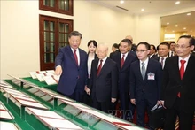 El secretario general del Partido Comunista de Vietnam, Nguyen Phu Trong, y su invitado chino miran los documentos firmados. (Fotografía: VNA)