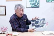 El periodista Tran Mai Huong con la foto titulada "El tanque del Ejército de Liberación entra al Palacio de Independencia al mediodía del 30 de abril de 1975". (Fotografía: VNA)