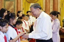 El presidente To Lam entrega regalos a los pequeños. (Fotografía: VNA)