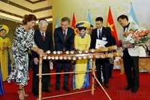 El entonces presidente argentino, Mauricio Macri, intenta tocar un instrumento musical tradicional vietnamita durante su visita al país indochino en 2019. (Fotografía: VNA)