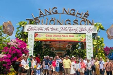 Turistas del Arcadia se toman fotos de recuerdo en la aldea de oficio tradicional de Truong Son, en Nha Trang. (Fotografía: baokhanhhoa.vn)