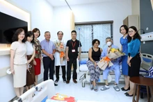 La directora general Vu Viet Trang, funcionarios y reporteros de la VNA felicitan al periodista cubano Moisés Pérez Mok luego de la exitosa cirugía. (Fotografía: VNA)