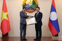 El embajador de Vietnam en Laos, Nguyen Ba Hung (izquierda), recibe la Orden de la Libertad (Issara) de Tercera Clase de Laos. (Fotografía: VNA)