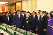 El secretario general del Partido Comunista de Vietnam, Nguyen Phu Trong, y su invitado chino miran los documentos firmados. (Fotografía: VNA)