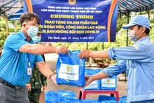 Entrega de ayudas a trabajadores afectados por el Covid-19 en Vietnam. (Fotografía: VNA)