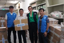 La representante jefa de la OMS en Vietnam, Angela Pratt, entrega los donativos a representantes de Vietnam. (Fotografía: Nhan Dan)