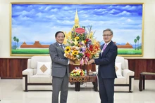 El embajador Nguyen Ba Hung (izquierda) felicita por la fecha al jefe del Departamento de Relaciones Exteriores del PPRL, Thongsavanh Phomvihane. (Fotografía: Nhan Dan)