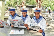Oficiales acantonados en la isla de Truong Sa (Spratly), del homónimo archipiélago vietnamita, leen el periódico Nhan Dan. (Fotografía: Dang Khoa)