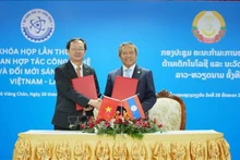 Los dos ministros intercambian documentos de la primera reunión del Comité de cooperación en Tecnología e Innovación Vietnam – Laos. (Fotografía: VNA)