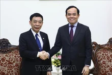 El vice primer ministro de Vietnam Tran Luu Quang (derecha) recibe al ministro del Interior de Laos, Thongchanh Manixay. (Fotografía: VNA)