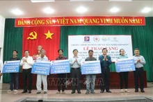 El expresidente del país Truong Tan Sang (tercero desde la derecha) entrega apoyo financiero a pescadores desfavorecidos en Ben Tre. (Fotografía: VNA)