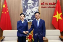 El ministro de Justicia de Vietnam, Le Thanh Long, sostiene una conversación con su homóloga china, He Rong. (Fotografía: VNA)