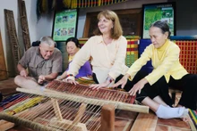Turistas extranjeros hacen de artesanos en festival de oficios tradicionales en Kim Bong
