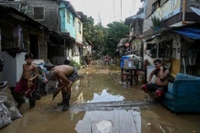 Los filipinos limpian sus casas inundadas después del súper tifón Noru, en septiembre de 2022. (Fotografía: philstar.com)