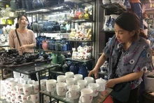 Clientes compran productos en el mercado de cerámica de Bat Trang, en Hanói. (Fotografía: VNA)