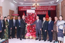 El subsecretario permanente del Comité del Partido en Ciudad Ho Chi Minh, Nguyen Ho Hai, (centro a la izquierda) entrega flores para felicitar al cónsul general adjunto de Laos, Amphay Souvannasen. (Fotografía: VNA)