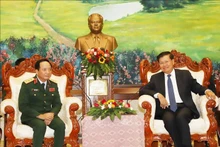 El coronel general Trinh Van Quyet, jefe de la Dirección General de Política del Ejército Popular de Vietnam (izquierda), y el secretario general del Partido Popular Revolucionario y presidente de Laos, Thongloun Sisoulith. (Fotografía: VNA)