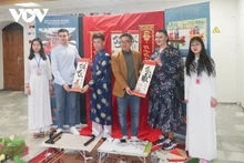 Estudiantes vietnamitas presentan obras de caligrafía tradicional a amigos extranjeros. (Fotografía: VOV)