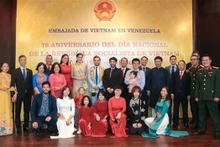 El personal de la Embajada y agencias representativas de Vietnam se toma fotos de recuerdo con los invitados. (Fotografía: VNA)