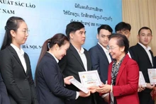 Nguyen Thi Doan, ex vicepresidenta de Estado y titular de la Asociación de Estímulo al Estudio de Vietnam, otorga becas a estudiantes de Laos. (Fotografía: VNA)