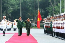 El jefe de la Dirección General de Política del Ejército Popular de Vietnam, Luong Cuong, y su homólogo laosiano, Thongloi Silivong, pasan revista a la guardia de honor. (Fotografía: VNA)