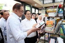El primer ministro de Vietnam, Pham Minh Chinh, y su homólogo malasio, Anwar Ibrahim, visitan una librería en la Calle del Libro en Hanói. (Fotografía: VNA)