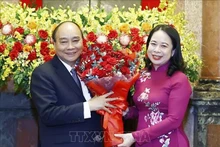 La presidenta interina Vo Thi Anh Xuan entrega flores a Nguyen Xuan Phuc. (Fotografía: VNA)