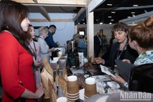 Visitantes a la feria degustan el café vietnamita. (Fotografía: Nhan Dan)