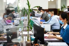 Funcionarios procesan trámites administrativos para los pobladores. (Fotografía: VNA)