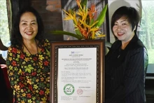 Ngo Kim Trang, subjefa del Instituto de Investigación Aplicada e Innovación en Empresas, entrega el certificado de estación de cero emisiones netas al complejo Suoi Rao Ecolodge. (Fotografía: VNA)