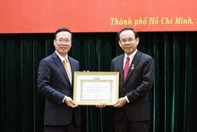El presidente vietnamita, Vo Van Thuong, entrega la insignia por los 45 años de membresía en el Partido Comunista de Vietnam a Nguyen Van Nen, secretario del Comité partidista de Ciudad Ho Chi Minh. (Fotografía: VNA)