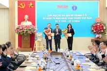 El compañero Le Quoc Minh entrega la placa conmemorativa “Por la carrera del Periódico Nhan Dan” a la ministra de Salud Pública, Dao Hong Lan, y al viceministro de la cartera Tran Van Thuan. (Fotografía: The Dai)