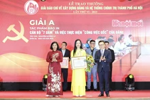 Los compañeros Le Quoc Minh y Nguyen Thi Tuyen entregan el premio A a una autora.