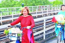Stella Ciorra en un programa de ciclismo para promover el "ao dai" vietnamita. (Fotografía: Nhan Dan)