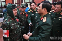 El teniente general Nguyen Tan Cuong (derecha) charla con los oficiales sobre la tarea encomendada. (Fotografía: Nhan Dan)