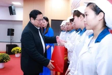 El primer ministro Pham Minh Chinh entrega obsequios a trabajadores. (Fotografía: VNA)