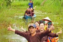 Turistas recorren el bosque en sampán en una zona de ecoturismo en Vietnam. (Fotografía: VNA)