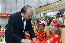 El presidente Nguyen Xuan Phuc saluda a los ancianos participantes en la ceremonia. (Fotografía: VNA)