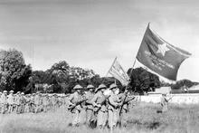 Una unidad de la División de la Capital, enarbolando la bandera “Determinación para luchar, determinación para vencer” entregada por el Presidente Ho Chi Minh, realiza la primera ceremonia de izado de bandera después de la liberación de Hanói, el mismo día histórico, 10 de octubre de 1954, en el patio de Cot Co (Torre de la Bandera), actual puerta de Doan Mon de la Ciudadela Imperial de Thang Long. (Foto archivada por VNA) 